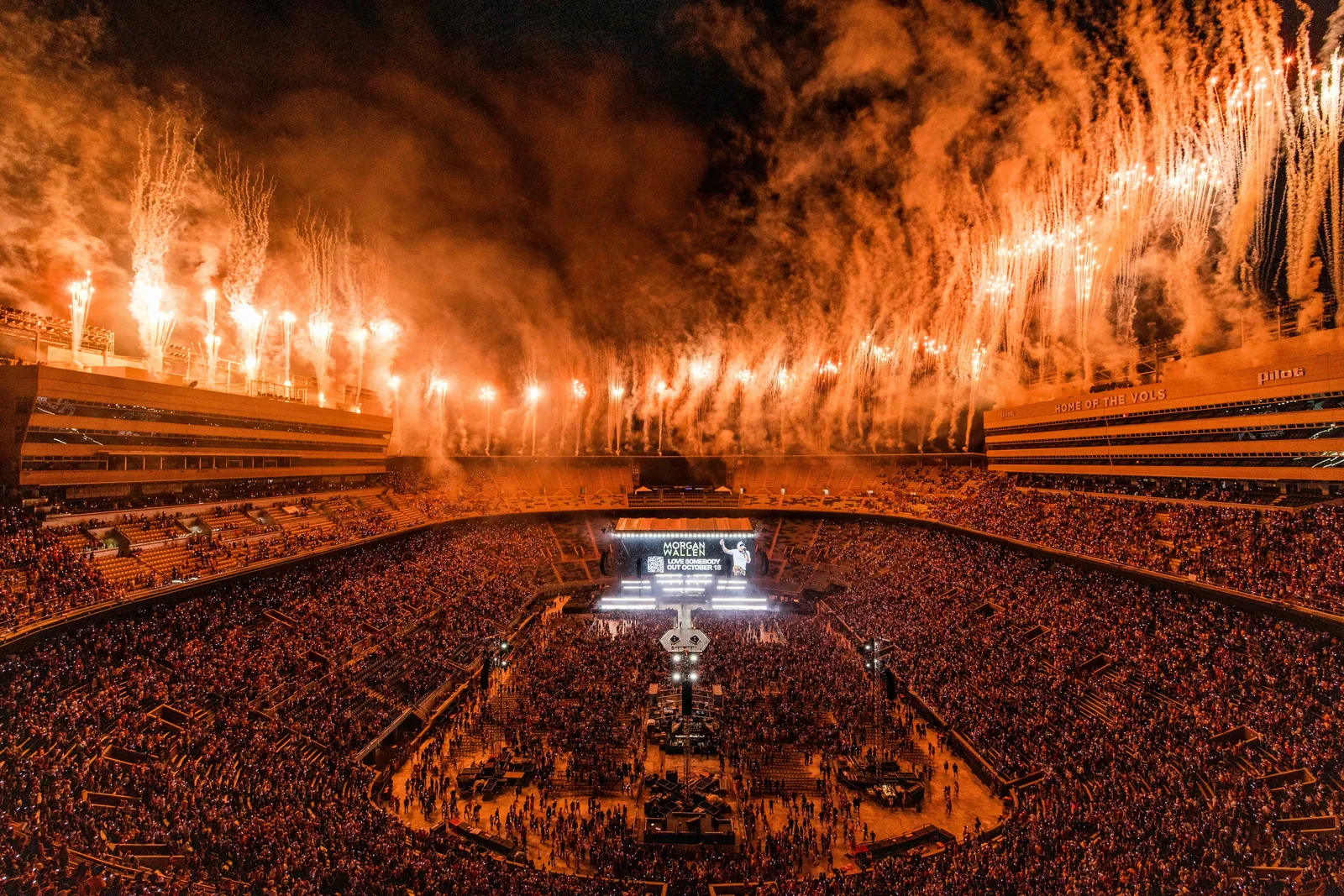 Arena show erupting in a field of pyrotechnics above the stage and audience
