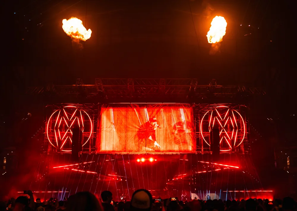 Morgan Wallen arena stage glowing red with pyrotechnics above the video screens