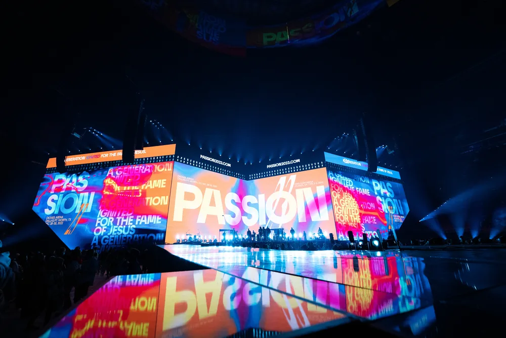 Passion production filling an arena with layered LED walls in blue, orange, and magenta